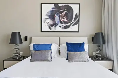 a bedroom with a large white bed with blue pillows at VayK - Chic Hotel Style Studio in Damac Hills in Dubai