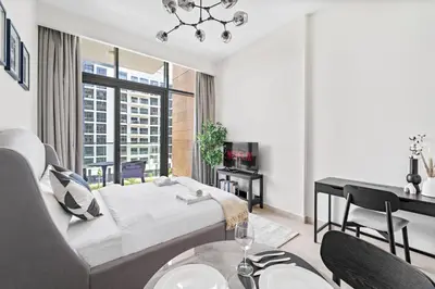 a bedroom with a bed and a desk and a table at VayK - Modern Studio in Prime Meydan Area in Dubai