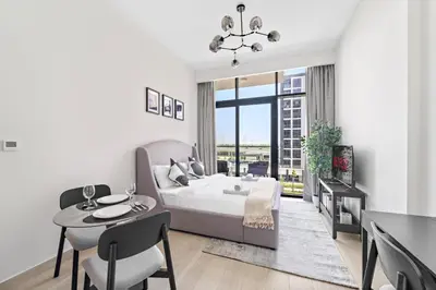a bedroom with a bed and a table and chairs at VayK - Modern Studio in Prime Meydan Area in Dubai
