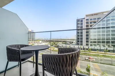 a balcony with a table and chairs and a view of a city at VayK - Modern Studio in Prime Meydan Area in Dubai