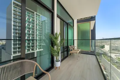a balcony with a chair and a potted plant on it at VayK - Amazing 1BR in Jvc in Dubai