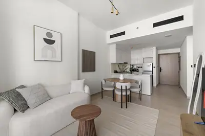 a white living room with a couch and a table at VayK - Amazing 1BR in Jvc in Dubai
