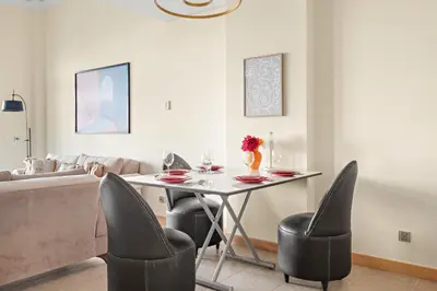 a living room with a table and chairs at VayK - Beachfront 1BR on Palm Jumeirah with Sea View in Dubai