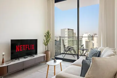 a living room with a tv and a large window at VayK - Heavenly Brand New 1BR in Jvc in Dubai