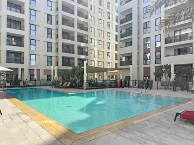 a large swimming pool in front of a building at VayK - Modern 1BR Getaway in Creek Harbour in Dubai
