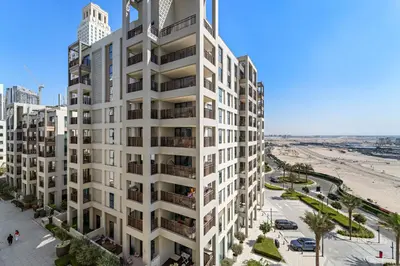 an aerial view of a white apartment building next to a beach at VayK - Modern 1BR Getaway in Creek Harbour in Dubai