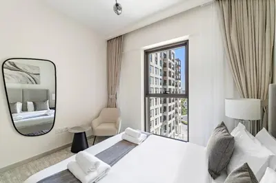 a bedroom with a large white bed and a mirror at VayK - Modern 1BR Getaway in Creek Harbour in Dubai