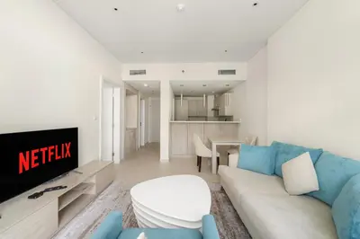 a living room with a couch and a tv at VayK - Modern 1BR on Palm Jumeirah in Dubai