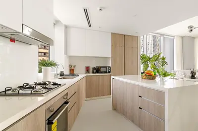 a kitchen with white counter tops and wooden cabinets at VayK - Elegant 2BR with Luxury Amenities in LIV Marina in Dubai