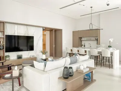 a living room with a white couch and a kitchen at VayK - Elegant 2BR with Luxury Amenities in LIV Marina in Dubai
