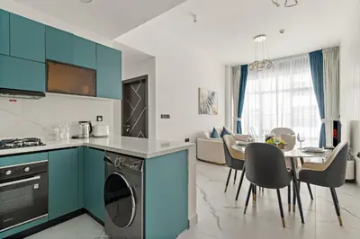 a kitchen with blue cabinets and a table with chairs at VayK - Spacious 2BR with Private Pool in Science Park in Dubai