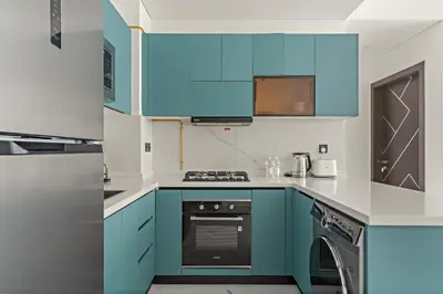 a kitchen with blue cabinets and a dishwasher at VayK - Spacious 2BR with Private Pool in Science Park in Dubai