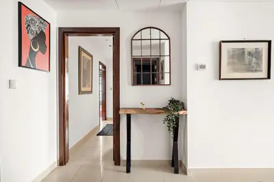 a hallway with a table and a mirror on the wall at VayK - Luxe 2BR with Stunning Marina Views in Dubai