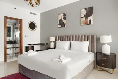 a bedroom with a large white bed and a mirror at VayK - Luxe 2BR with Stunning Marina Views in Dubai
