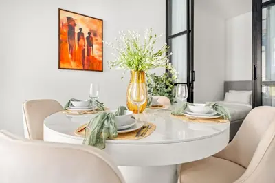 a white dining room with a white table and chairs at VayK - Contemporary 2BR in Dubai Marina in Dubai