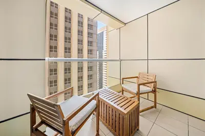 a balcony with a bench and a chair in a building at VayK - Contemporary 2BR in Dubai Marina in Dubai