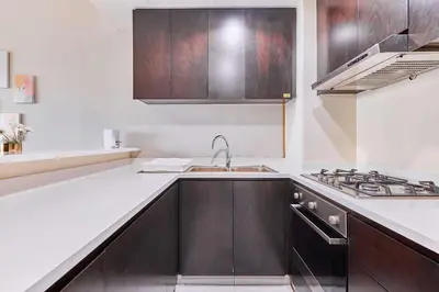 a kitchen with a sink and a stove top oven at Home Away 2BR in Dubai