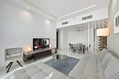 a living room with a couch and a tv at Luxury 2BDR In Burj Khalifa View Business Bay in Dubai