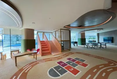 a living room with a slide and a table at AWS Holiday Homes - Stay in Style in Dubai