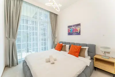 a bedroom with a large bed and a large window at HAVN - 2 bedroom in Urban Oasis, Dubai Canal View in Dubai