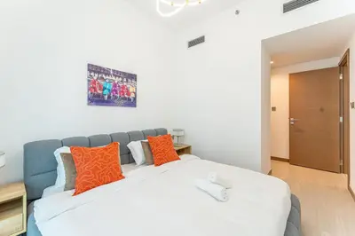 a bedroom with a bed with orange and blue pillows at HAVN - 2 bedroom in Urban Oasis, Dubai Canal View in Dubai