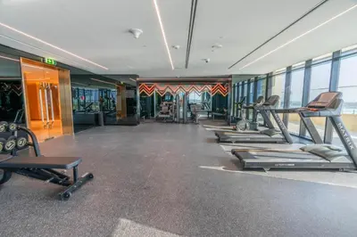 a gym with a row of treadms and machines at HAVN - 2 bedroom in Urban Oasis, Dubai Canal View in Dubai