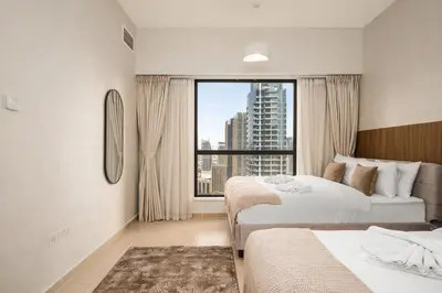 a hotel room with two beds and a large window at Luxury Beachfront 4BR with Sea & Marina Views in Dubai