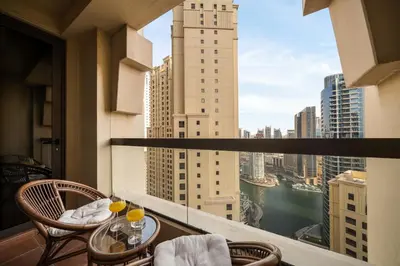a balcony with a table and chairs and a view of a city at Luxury Beachfront 4BR with Sea & Marina Views in Dubai