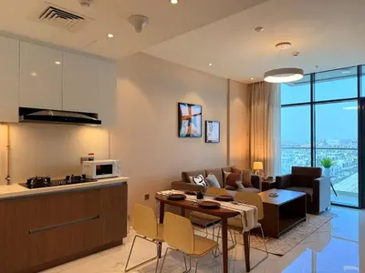 a kitchen and living room with a couch and a table at Spacious 1BR- Sepcoo III Residence Al Furjan-1009 in Dubai