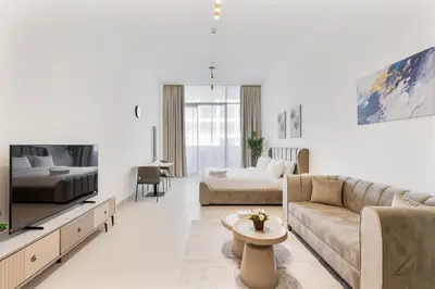 a living room with a couch and a tv at ALiving Cozy Studio I Binghatti Galaxy, JVC- G02 in Dubai