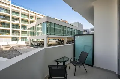 a balcony with two chairs and a table and a building at ALiving Cozy Studio I Binghatti Galaxy, JVC- G02 in Dubai