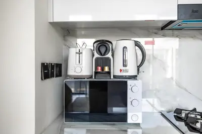 a kitchen with a coffee maker on top of a microwave at New! Cozy 1BR in Binghatti House Pool and Gym in JVC in Dubai