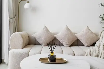 a living room with a couch and a table with pillows at New! Cozy 1BR in Binghatti House Pool and Gym in JVC in Dubai