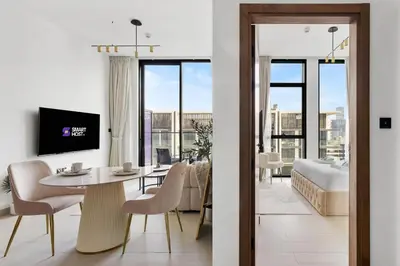 a living room with a table and chairs and a bedroom at New! Cozy 1BR in Binghatti House Pool and Gym in JVC in Dubai