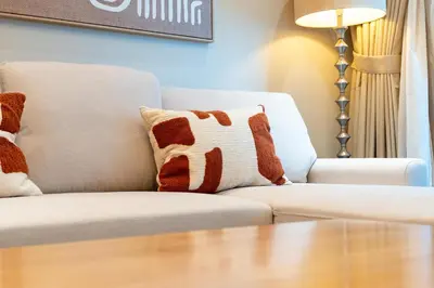 a living room with a couch and a table at Vacay Lettings - Elite Residence - 1 BR - Partial Sea View in Dubai