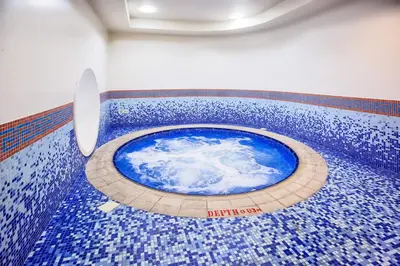 a room with a blue tile floor with a blue pool at Vacay Lettings - Elite Residence - 1 BR - Partial Sea View in Dubai