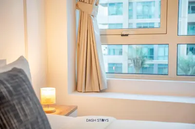 a bedroom with a window and a couch and a lamp at Lux 2BR in Dubai Marina Walk to Beach & Metro in Dubai