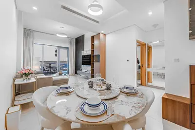 a white dining room with a table and chairs at Escape24 Elegant 1BR with City View near Dubai Mall in Dubai