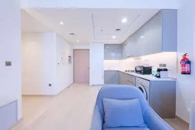 a kitchen with a blue chair in a room at Spacious 2BHK at Azizi Riviera 22 Meydan in Dubai
