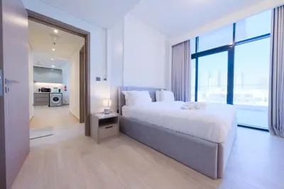 a bedroom with a large bed and a large window at Spacious 2BHK at Azizi Riviera 22 Meydan in Dubai