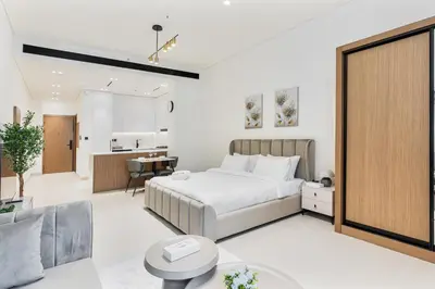 a bedroom with a bed and a living room at ALiving Brand New & Modern Studio I Binghatti Galaxy, JVC- G01 in Dubai