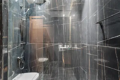 a tiled bathroom with a toilet and a shower at ALiving Brand New & Modern Studio I Binghatti Galaxy, JVC- G01 in Dubai