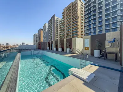 a swimming pool on top of a building with tall buildings at ALiving Brand New & Modern Studio I Binghatti Galaxy, JVC- G01 in Dubai