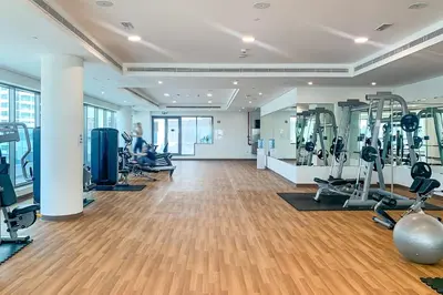 a gym with treadmills and machines in a room at Frank Porter - The Bay in Dubai