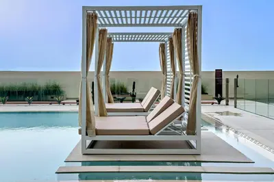 a couple of chairs sitting next to a pool at Stylish 1BR Studio Unit Balcony & Pool in Dubai