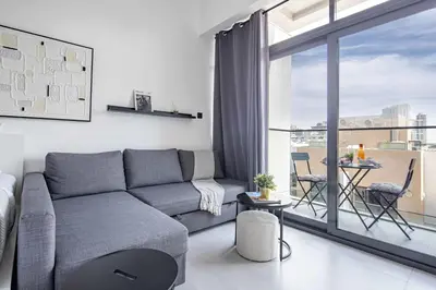 a living room with a couch and a large window at Frank Porter - Oxford Boulevard in Dubai