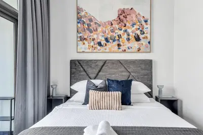 a bedroom with a large white bed with blue pillows at GuestReady - 1BR l Burj Khalifa & Canal Views in Dubai