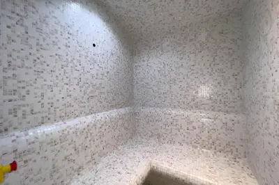 a corner of a bathroom with white tiled walls at GuestReady - 1BR l Burj Khalifa & Canal Views in Dubai