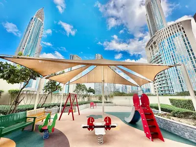 a playground with a large umbrella and play equipment at EasyGo - Elegant 1BR in Downtown Dubai in Dubai