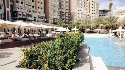 a pool with chairs and umbrellas at a hotel at Luxury Palm Jumeirah Apartment with Sea Views Balqis Residence in Dubai